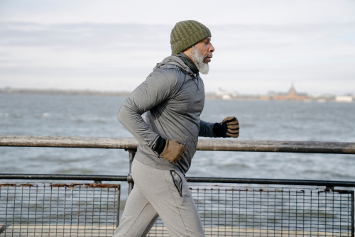 Older black man running by pier