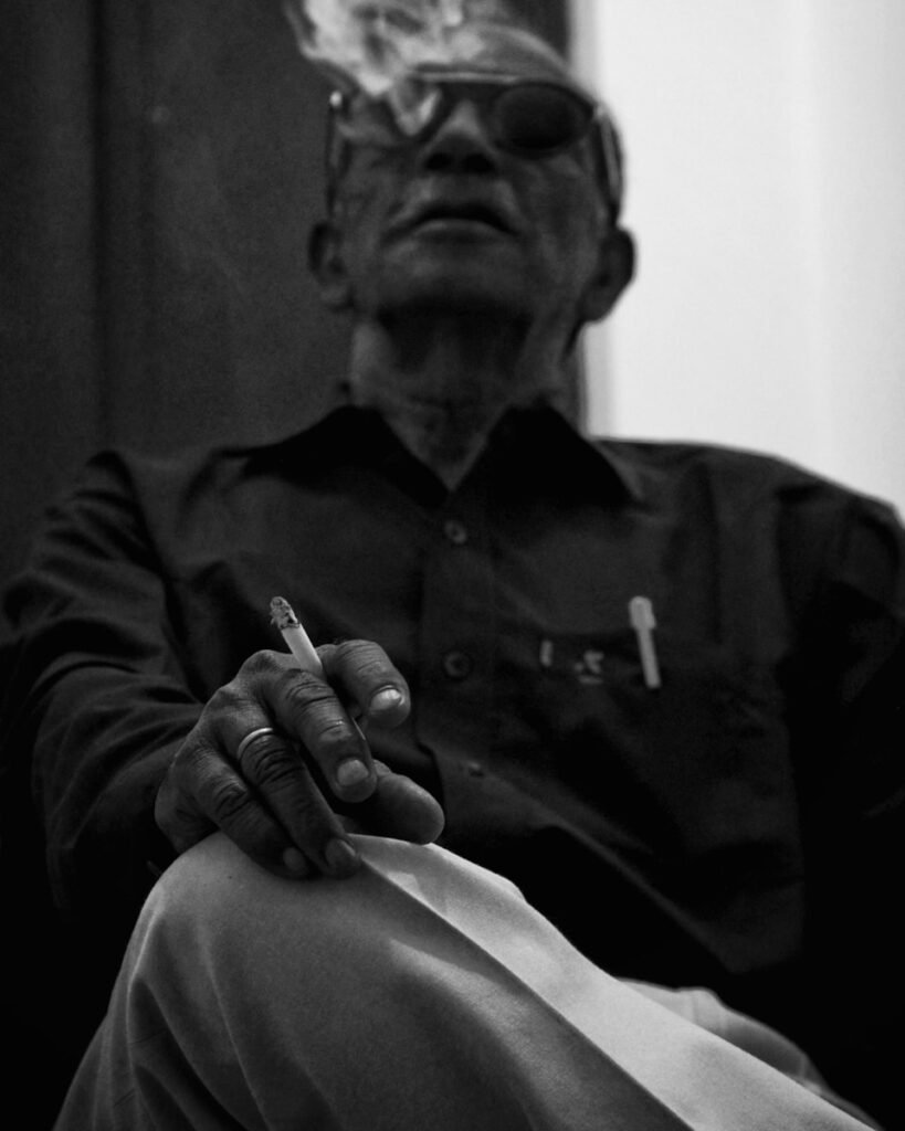 grayscale photo of man smoking cigarette